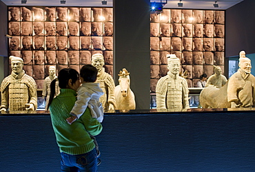 Tourists view Terracotta warriors on display in the Shaanxi History Museum, Xian, China