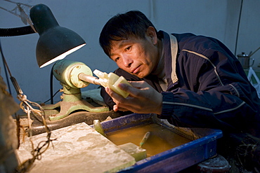 Jade craftsman at work in the Huahui Jade Factory and Showroom, Xian, China