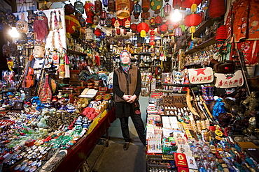 Chinese woman of Hui Minority Group selling souvenirs at market stall in Moslem district of Xian, China