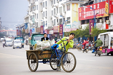 Woman with bicycle delivery cart in Yangshuo street, China