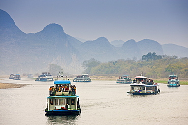 Tourist boats travel along Li River between Guilin and Yangshuo, China