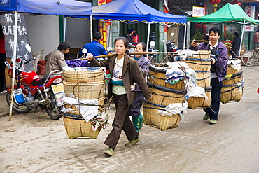 People carry baskets to market day in Baisha, near Guilin, China