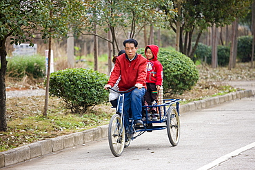 Family on a tricycle in Guilin, China. China has a one child family planning policy to reduce population.