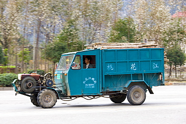 Delivery tractor truck containing pile of wood in Guilin, China. China's construction industry is thriving.