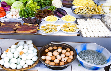 Duck breasts, battered fish and preserved '1000 year old' eggs, at food stall in Fengdu, China