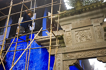 Workman carries out restoration repairs at City of Ghosts, Fengdu, China