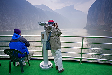 Tourists take photographs from the deck of a Victoria Line Cruise Ship, Yangze River, China