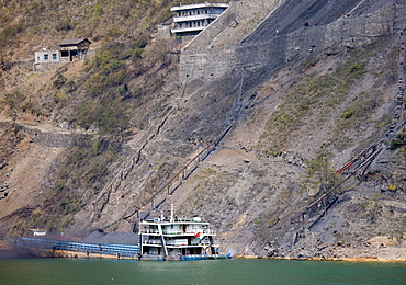 Coal slides down hillside to fill freight ship, in Three Gorges area, Yangtze River, China