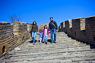 American Chinese family walk the ancient Great Wall of China at Mutianyu, north of Beijing, China