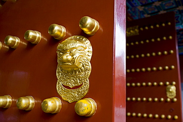 Nails and lion-head knocker on gate to Tower of Buddhist Incense at The Summer Palace, Beijing, China