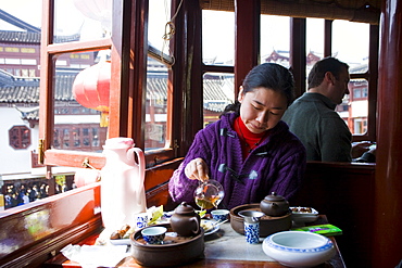 Woman drinking tea in the Huxinting Teahouse, Yu Garden Bazaar Market, Shanghai, China