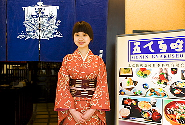 Hostess stands at the entrance of Gonin Byakusho Japanese Restaurant in the Beijing Hotel, China