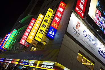 McDonalds fastfood restaurant with advertising alongside Chinese companies on Wangfujing Street, Beijing, China