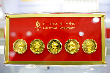 2008 Olympic Games Fuwa mascot characters medallion coins in souvenir shop, Wangfujing Street, Beijing, China