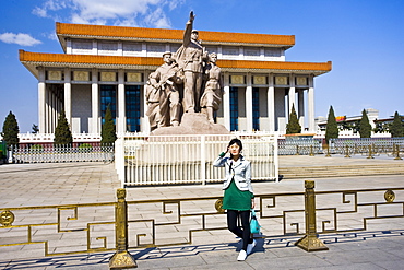 Tourist by statue elebrating the navy, army, airforce and workers, by Mao's Mausoleum, Tian'an Men Square, China