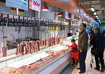 Shoppers at meat counter in supermarket in Chongqing, China