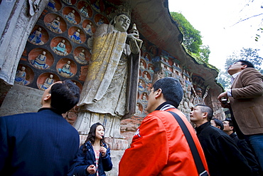 Tourists view Buddha statues Dazu rock carvings at Mount Baoding, Chongqing, China