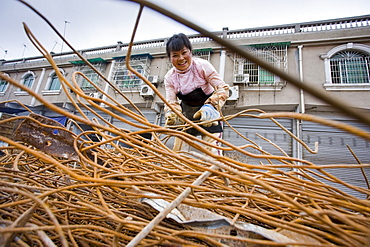 Woman working at metal recycling steel in Dazu County, Chongqing, China