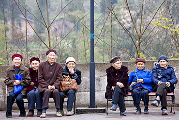 Elderly Chinese women sit together on benches in Chongqing, China