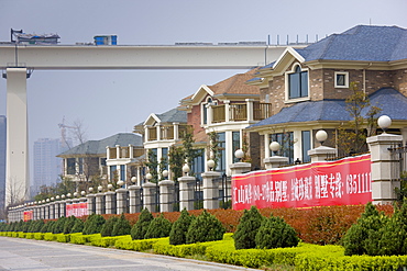 Western-style newly built modern river front housing development by railway bridge in Yichang, China