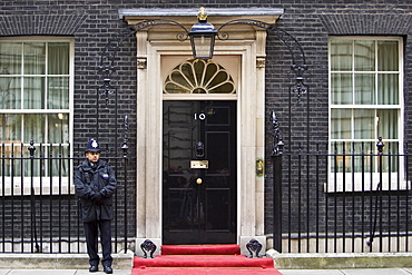 Armed policeman guards Number 10 Downing Street, official home of the British Prime Minister, London, UK