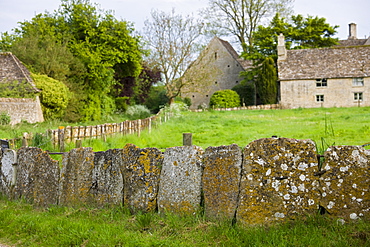 Cotswolds village, country lane and old stone slab fencing in Kelmscott, The Cotswolds, Gloucestershire, UK