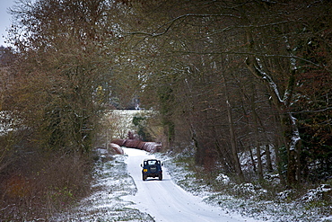 Land Rover in country lane in frosty wintry landscape in The Cotswolds, Oxfordshire, UK