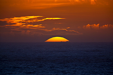 Sun setting in the west over the ocean at Woolacombe, North Devon, UK