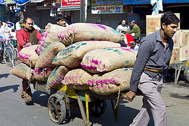 Porters with sacks of dates at Khari Baoli spice and dried foods market, Old Delhi, India