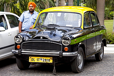 Sikh taxi driver with classic Ambassador taxi at The Imperial Hotel, New Delhi, India