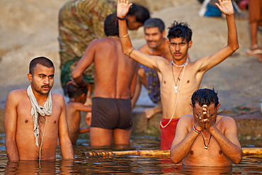 Indian Hindu pilgrims bathing in The Ganges River at Dashashwamedh Ghat in Holy City of Varanasi, Benares, India