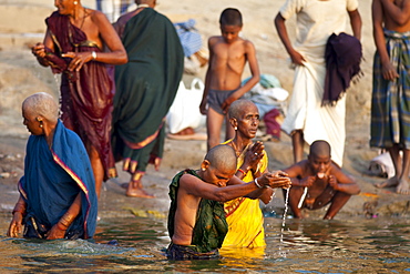 Indian Hindu pilgrims bathing in The Ganges River at Dashashwamedh Ghat in Holy City of Varanasi, Benares, India