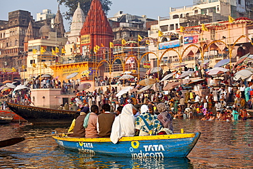 Tourists in boat advertising TATA Indicom on River Ganges at Varanasi, Benares, Northern India