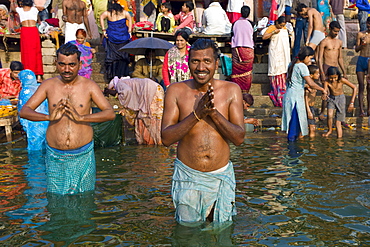 Indian Hindu pilgrims bathing in The Ganges River at Dashashwamedh Ghat in Holy City of Varanasi, Benares, India