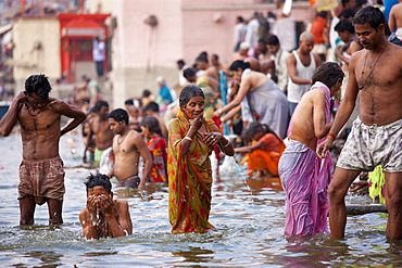 Indian Hindu pilgrims bathing in The Ganges River at Dashashwamedh Ghat in Holy City of Varanasi, Benares, India