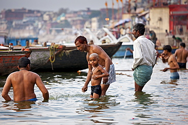 Indian Hindu pilgrims bathing in The Ganges River at Dashashwamedh Ghat in Holy City of Varanasi, Benares, India