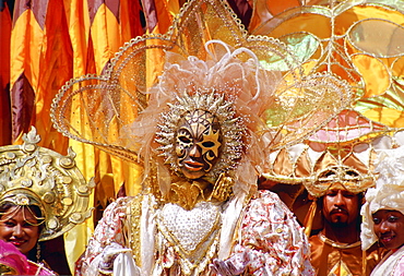 Carnival dancers wearing traditional costumes in pastel colours and gold in Trinidad, Caribbean