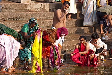 Indian Hindu pilgrims bathing in The Ganges River at Dashashwamedh Ghat in Holy City of Varanasi, Benares, India