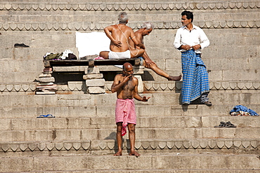 Men bathing at Dharbanga Ghat by the Ganges River in City of Varanasi, Benares, Northern India