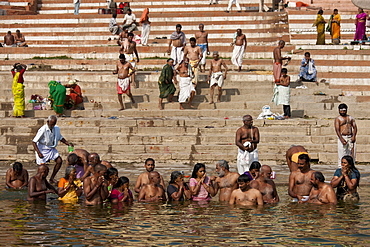 Indian Hindu men and women bathing and praying in the River Ganges by Kshameshwar Ghat in holy city of Varanasi, India