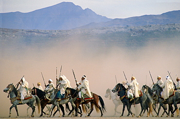 Moroccan horsemen riding in an equestrian Fantasia in Morocco.