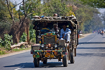 Indian workers travel in brightly coloured truck in Agra, Uttar Pradesh, India