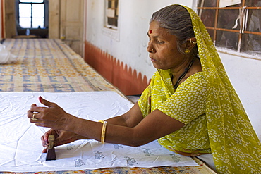 Indian woman die stamping textiles at Dastkar women's craft co-operative, the Ranthambore Artisan Project, in Rajasthan, India