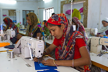 Indian woman sewing textiles at Dastkar women's craft co-operative, the Ranthambore Artisan Project, in Rajasthan, Northern India