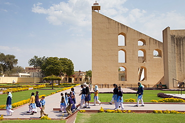 Students on a visit to The Observatory walk around the stone instruments in Jaipur, Rajasthan, Northern India