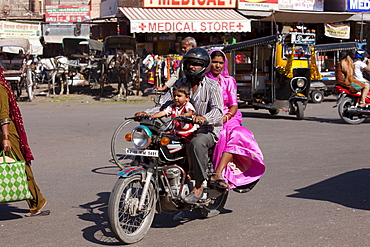 Indian family riding motorcycle, street scene at Sardar Market at Girdikot, Jodhpur, Rajasthan, Northern India