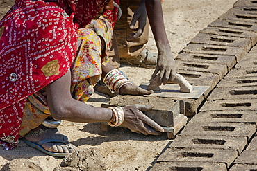 Indian family forming bricks made from mud clay at Khore Bricks Factory, Rajasthan, Northern India