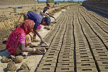 Indian family forming bricks made from mud clay at Khore Bricks Factory, Rajasthan, Northern India