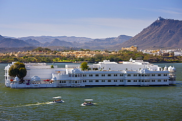 The Lake Palace Hotel, Jag Niwas, on island site on Lake Pichola with tourist boats arriving and leaving in Udaipur, Rajasthan, India