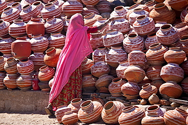 Indian woman selling clay water pots on sale in old town Udaipur, Rajasthan, Western India,